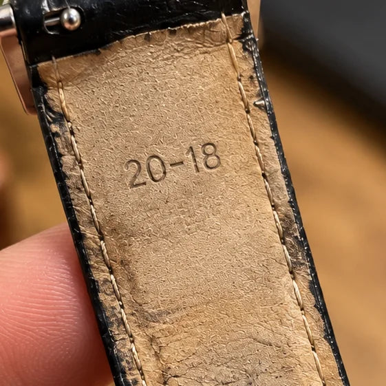 The underside of a worn leather strap, with 20-18 stamped into the lining near the lug end.